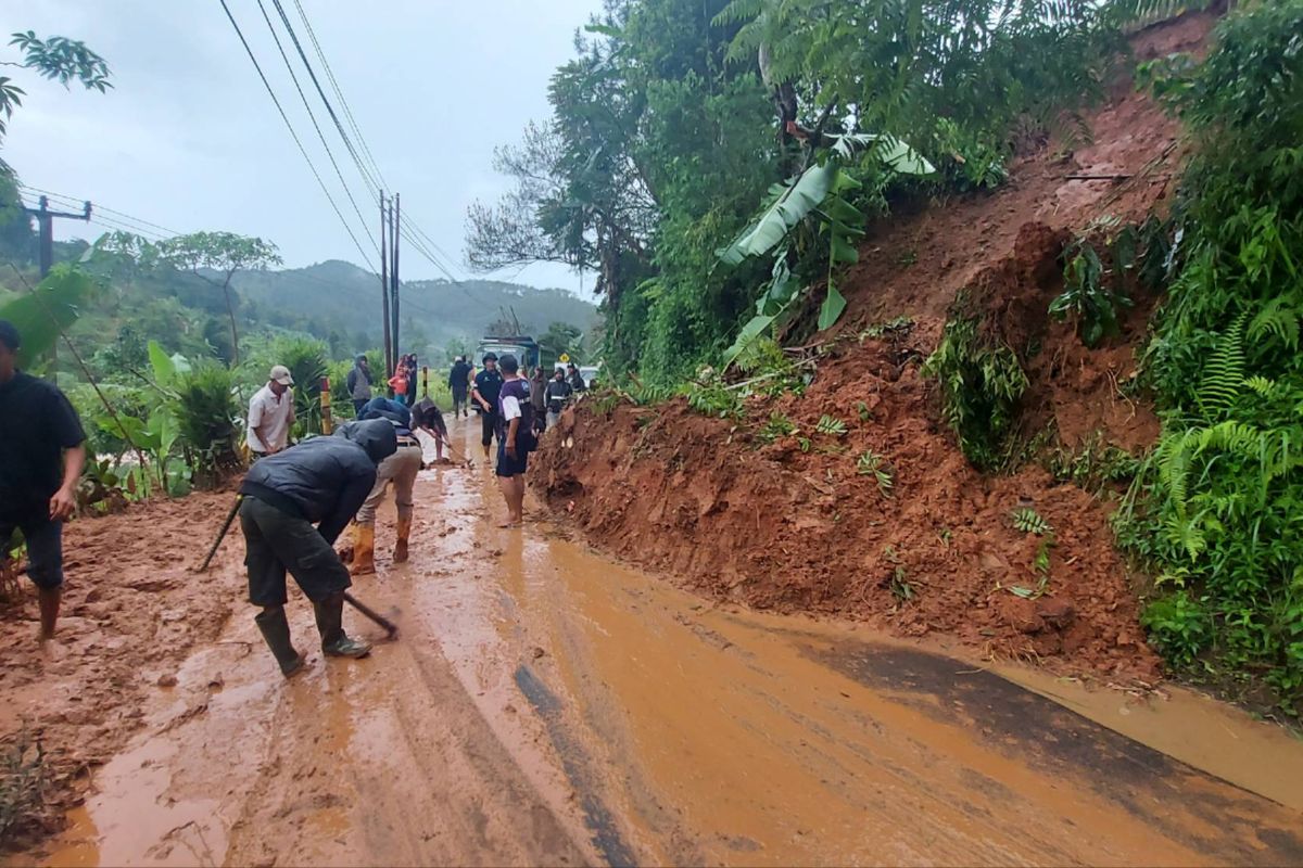 Warga mengevakuasi material longsor di Jalan Raya Gununghalu, Bandung Barat.
