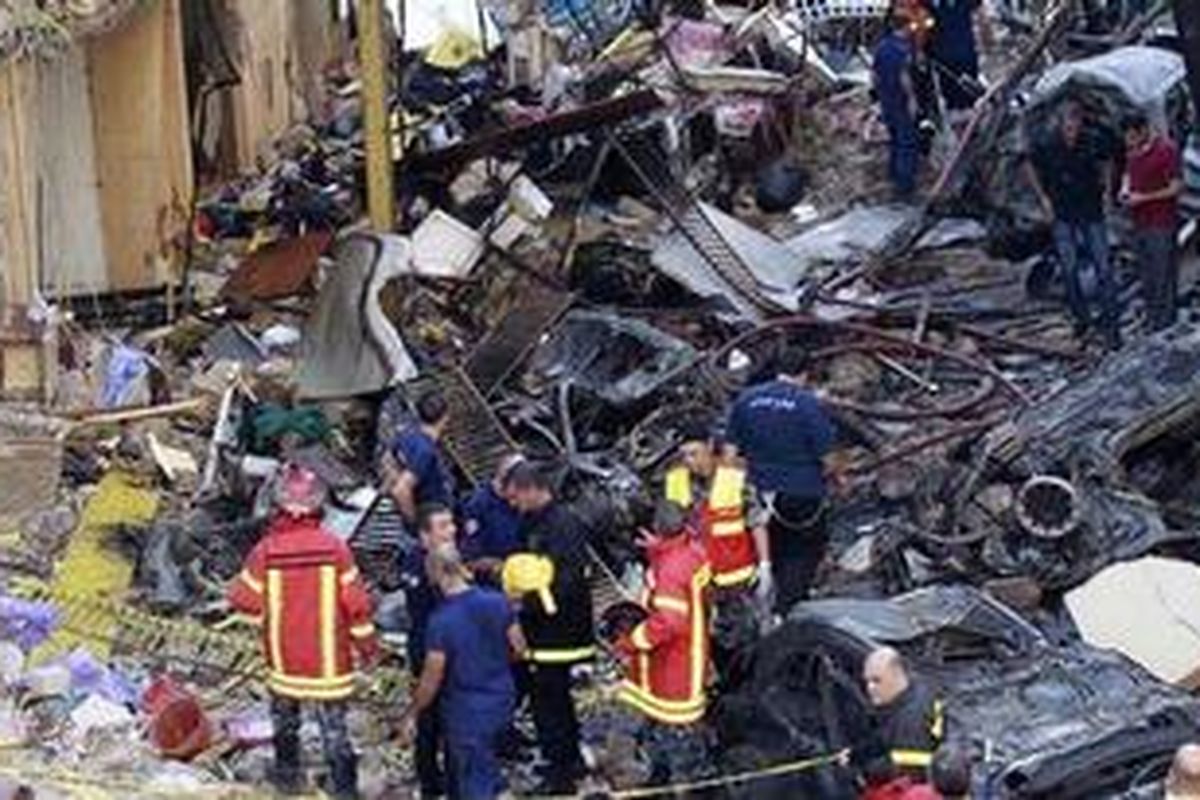 Para petugas penyelamat dan pemadam kebakaran memeriksa lokasi ledakan bom di Ashrafieh, sebuah wilayah yang berpenduduk mayoritas Kristen di Beirut, Lebanon, Jumat (19/10/2012). Bom mobil tersebut menewaskan delapan orang dan melukai 78 orang lainnya. 