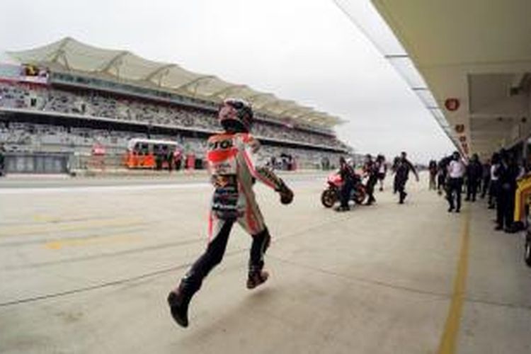Pebalap Repsol Honda asal Spanyol, Marc Marquez, berlari di pit Sirkuit Americas menuju motor keduanya saat menjalani sesi kualifikasi GP Americas di Austin, Sabtu (11/4/2015).