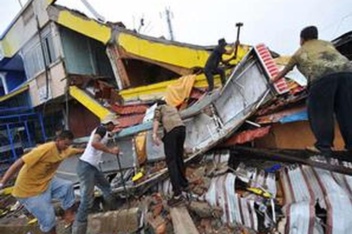 Warga berusaha mencari korban yang terjebak di reruntuhan bangunan pascagempa di Padang, Sumatera Barat, Kamis (1/10).