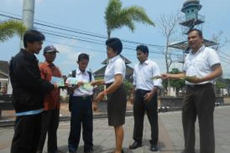 Kepala kejaksaan Negeri Demak, Nur Asiah, membagi stiker kepada pengguna jalan di depan alun-alun Demak, dalam rangka memperingati hari anti korupsi sedunia, Selasa ( 9/12/2014)