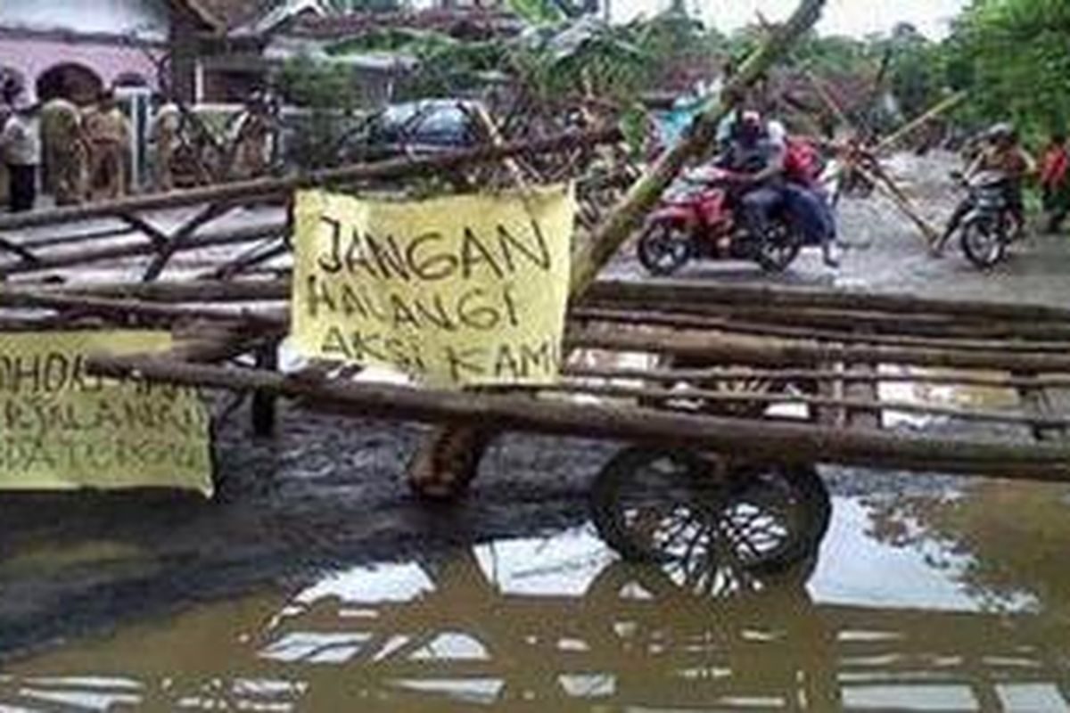 Ratusan warga di sepanjang jalan Kebonrojo Grati Pasuruan terpaksa memblokade dengan balok dan bebatuan sebagai protes jalan yang tidak kunjung diperbaiki.