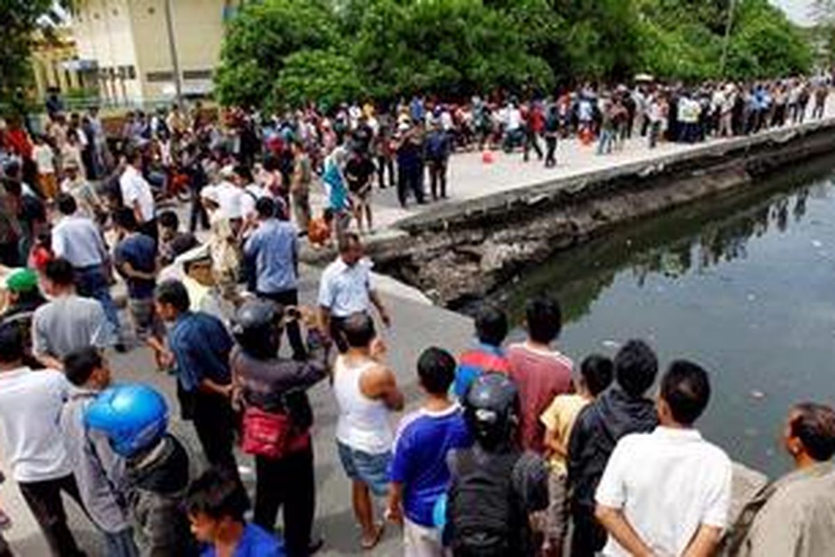 Jalan RE Martadinata, Jakarta Utara, yang ambrol sepanjang 103 meter menjadi tontonan warga, Kamis (16/9/2010). Jalan yang menghubungkan Pelabuhan Tanjung Priok dengan pusat kota ini ambrol sekitar pukul 03.15.