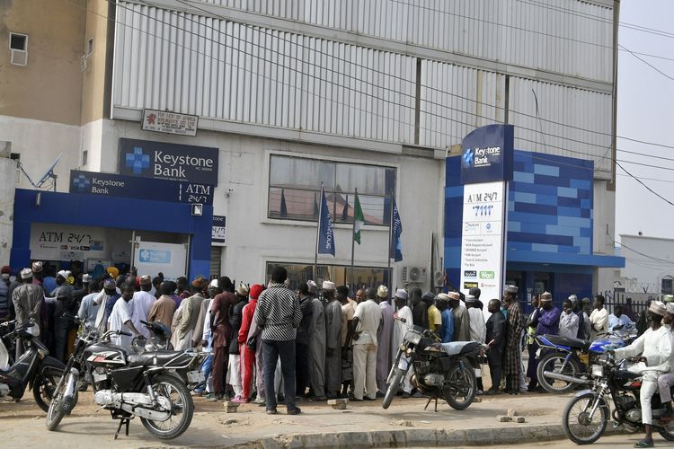 Antrean ATM yang mengular sampai berjam-jam akibat krisis uang tunai Nigeria di Kando pada 8 Februari 2023. Selama berminggu-minggu negara ini kekurangan pasokan bahan bakar, dan kini krisis Nigeria diperparah dengan kelangkaan uang tunai baru jelang pemilu.