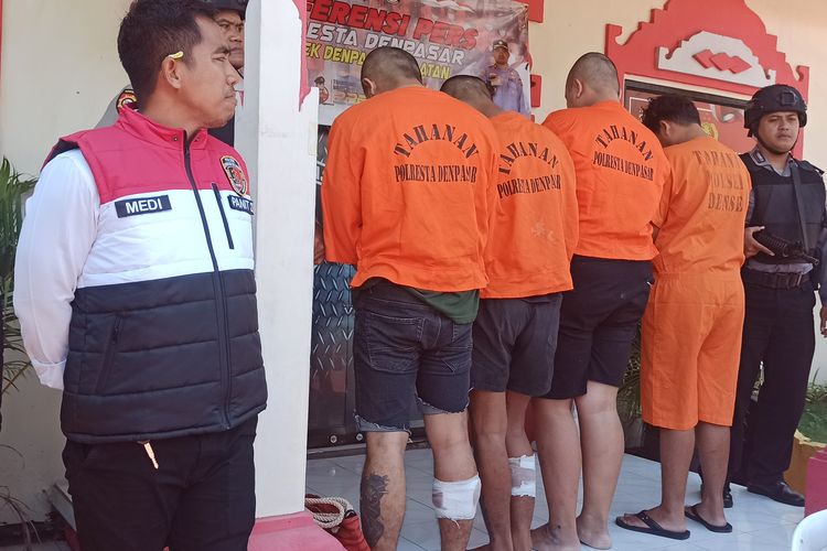 IKSDD (22), dan RAS(22), berdiri dalam kondisi kaki panjang usai ditembak polisi dalam konferensi pers pengungkapan kasus penjambretan terhadap WNA asal Korea Selatan di Markas Polsek Denpasar Selatan, pada Selasa (22/10/2024). KOMPAS.com/ Yohanes Valdi Seriang Ginta