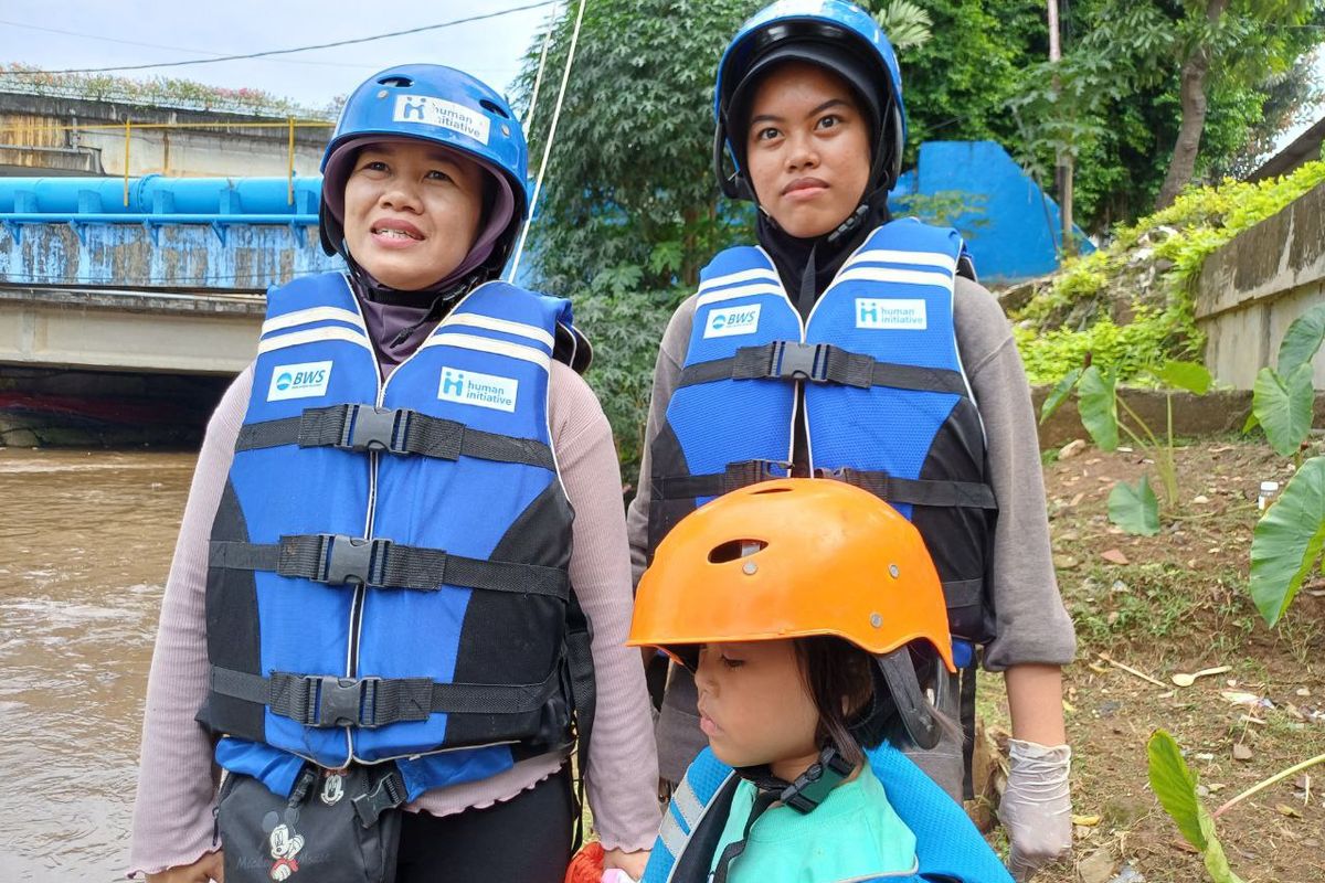Yuli (40) dan dua anaknya seusai menyusuri aliran Kali Ciliwung, Jakarta Pusat, Minggu (9/7/2023). 