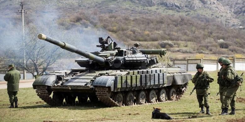 Pasukan Rusia sedang bersiaga di dekat sebuah tank di pangkalan militer Perevalne, Crimea.