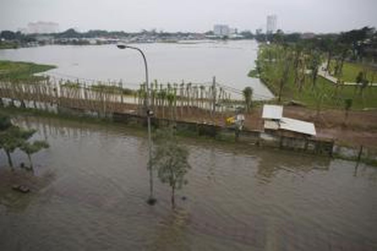 Waduk Ria Rio di Kelurahan Kayu Putih, Kecamatan Pulo Gadung, Jakarta Timur, tidak dapat menampung banjir hingga meluber ke Jalan DI Panjaitan, Rabu (5/2/2014). Genangan air di kawasan Cempaka Putih tersebut membuat kemacetan parah.