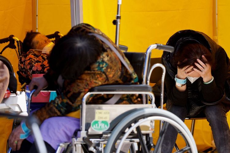 Pasien bereaksi di area perawatan darurat penyakit Covid-19 di luar rumah sakit di Hong Kong, Senin (28/2/2022). 