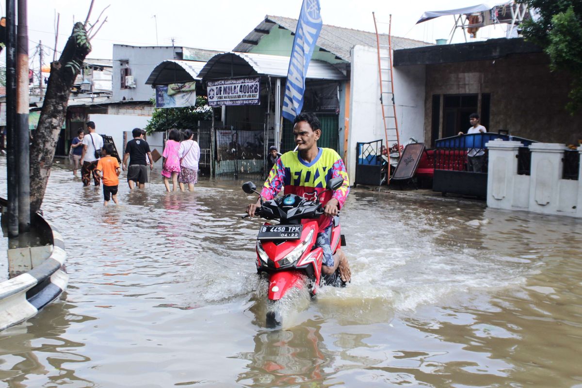 Pengendara sepeda motor nekat melintasi jalan yang tergenang air di Jalan Pusdiklat Depnaker, Makasar, Jakarta Timur, Kamis (2/1/2020). Sebelumnya, daerah ini dilanda banjir setinggi 1,5 meter yang dimana listrik-listrik dipadamkan.