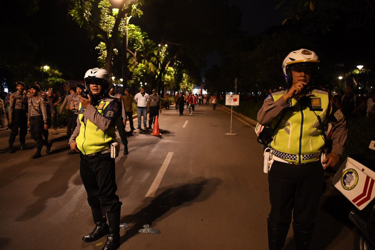 Petugas kepolisian berjaga seusai terdengar ledakan di kawasan parkir timur Senayan, Jakarta, Minggu (17/2/2019). 