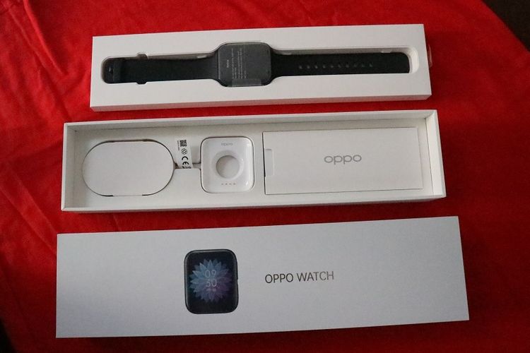 Isi kotak kemasan Oppo Watch terdiri dari satu unit arloji pintar lengkap dengan dua strip, charger tanpa kepala, dan buku panduan.