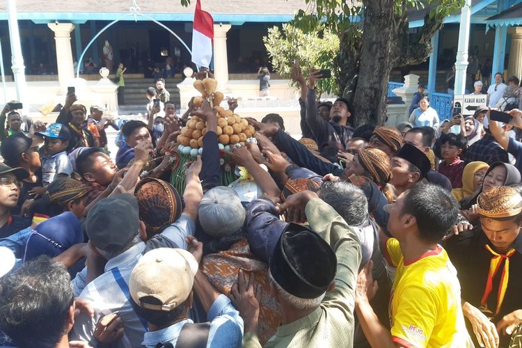 Pengunjung berebut gunungan dalam kirab hajad dalem garebeg besar tahun ehe 1956 di Masjid Agung Solo, Kamis (29/6/2023).