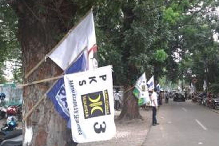 Deretan bendera partai yang terpaku di pohon sepanjang jalan menuju rumah Polonia, tempat deklarasi capres-cawapres dari Partai Gerindra, di Jalan Cipinang Cempedak, Otista, Jakarta Timur, Senin (19/5/2014)
