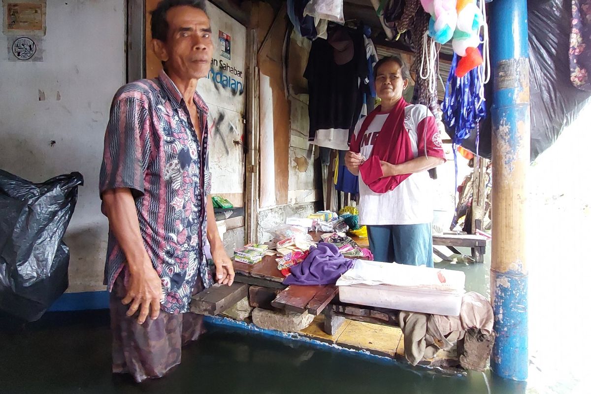 Sepasang lansia  di RT 15 RW 03, Tegal Alur, Kalideres, Jakarta Barat, hanya bisa pasrah ketiga banjir menerjang satu gerobak dagangan pada Selasa (18/1/2022) sekitar pukul 10.00 WIB.