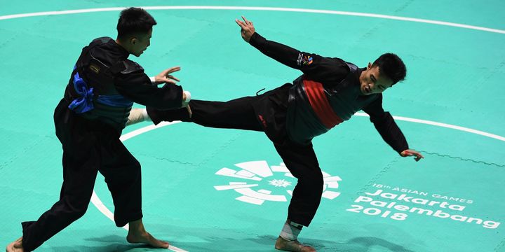 Pesilat Indonesia Abdul Malik (kanan) bertanding melawan pesilat Vietnam Dinh Tuan Nguyen (kiri) dalam babak 16 besar Kelas B Putra Asian Games 2018 di Padepokan Pencak Silat Taman Mini Indonesia Indah (TMII), Jakarta, Kamis (23/8)/2018.  