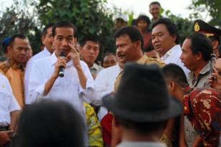 Presiden Indonesia Joko Widodo (kiri) berdiskusi dengan warga pengungsi erupsi Gunung Sinabung di Desa Gurukinayan, Karo,Rabu (29/10). Blusukan perdana Presiden Indonesia Joko Widodo ke Tanah Karo tersebut, melihat kondisi pengungsi erupsi Gunung Sinabung serta memberikan bantuan dan mencari solusi penyelesaian proses relokasi bagi warga korban Sinabung.