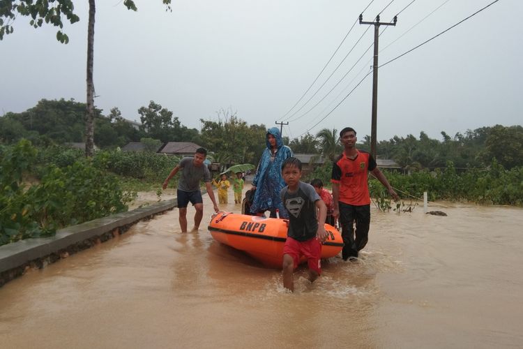 Relawan tengah menyeberangkan warga Desa Tamanmekar, Kecamatan Pangkalan, Kabupaten Karawang di banjir akibat meluapnya Sungai Cikereteg dan Sungai Citaman, Senin (24/2/2020).