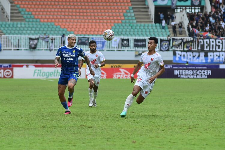 Penyerang Persib Bandung Ciro Alves tengah berlari berusaha menguasai bola menghindari pemain PSM Makassar Agung Mannan dalam laga pekan ke-24 Liga 1 2022-2023, Selasa (14/2/2023) di Stadion Pakansari, Cibinong, Kabupaten Bogor.