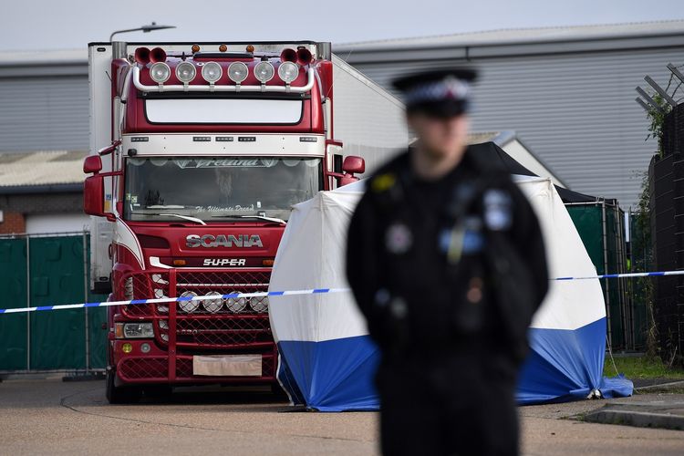 Foto yang diambil pada 23 Oktober 2019 memperlihatkan seorang polisi berjaga di depan truk di Grays, timur London, Inggris, di mana dalam kontainernya, aparat menemukan 39 mayat yang kemudian terkonfirmasi adalah warga negara Vietnam.