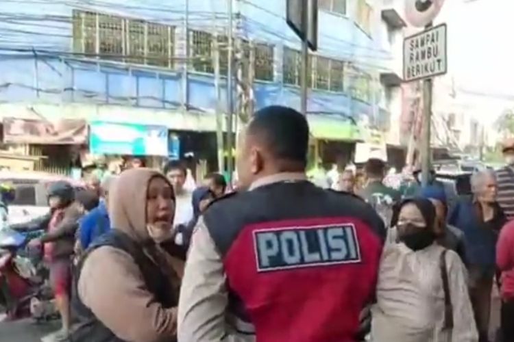 Seorang wanita berinisial HFR (memakai jaket berkupluk) menganiaya polisi karena tidak terima ditegur saat melawan arus di bawah flyover Kampung Melayu, Jatinegara, Jakarta Timur, Kamis (30/6/2022) pagi.