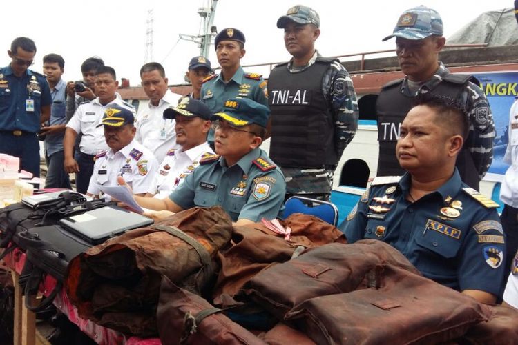 Danlanal Dumai Kolonel Laut (E) Yose Aldiano (tengah) memperlihatkan barang-barang over kapasitas yang diamankan pada KM Jelatik saat konferensi pers di Pelabuhan Sungai Duku, Pekanbaru, Rabu (11/7/2018).