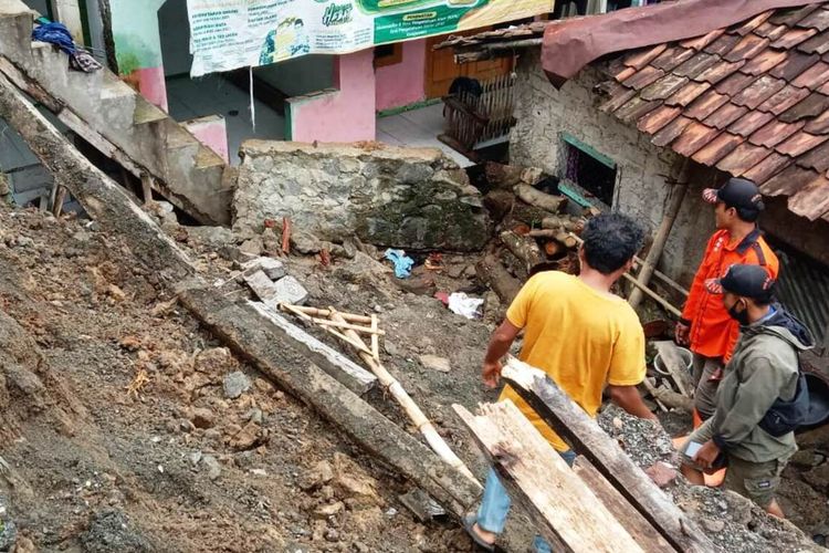 Sejumlah warga di Kabupaten Cianjur, Jawa Barat, sedang berupaya mengevakuasi tubuh seorang remaja perempuan yang tewas tertimbun material tembok penahan tanah, Selasa (28/12/2021).