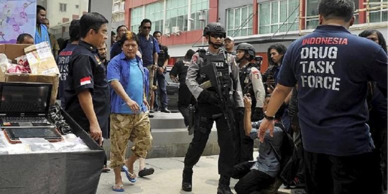 Terpidana mati kasus narkoba yang ditahan di Nusakambangan, Freddy Budiman (baju dan kaus biru), dihadirkan dalam rilis pengungkapan pabrik narkoba oleh Direktorat Tindak Pidana Narkoba Polri di ruko Mutiara Taman Palem, Cengkareng, Jakarta Barat, Selasa (14/4). Pabrik narkoba yang memproduksi ekstasi tersebut merupakan jaringan pengedar narkoba yang diduga dikendalikan oleh terpidana mati Freddy Budiman. Jaringan tersebut juga mengedarkan narkoba jenis baru, CC4, yang mempunyai bentuk seperti lembaran prangko. 