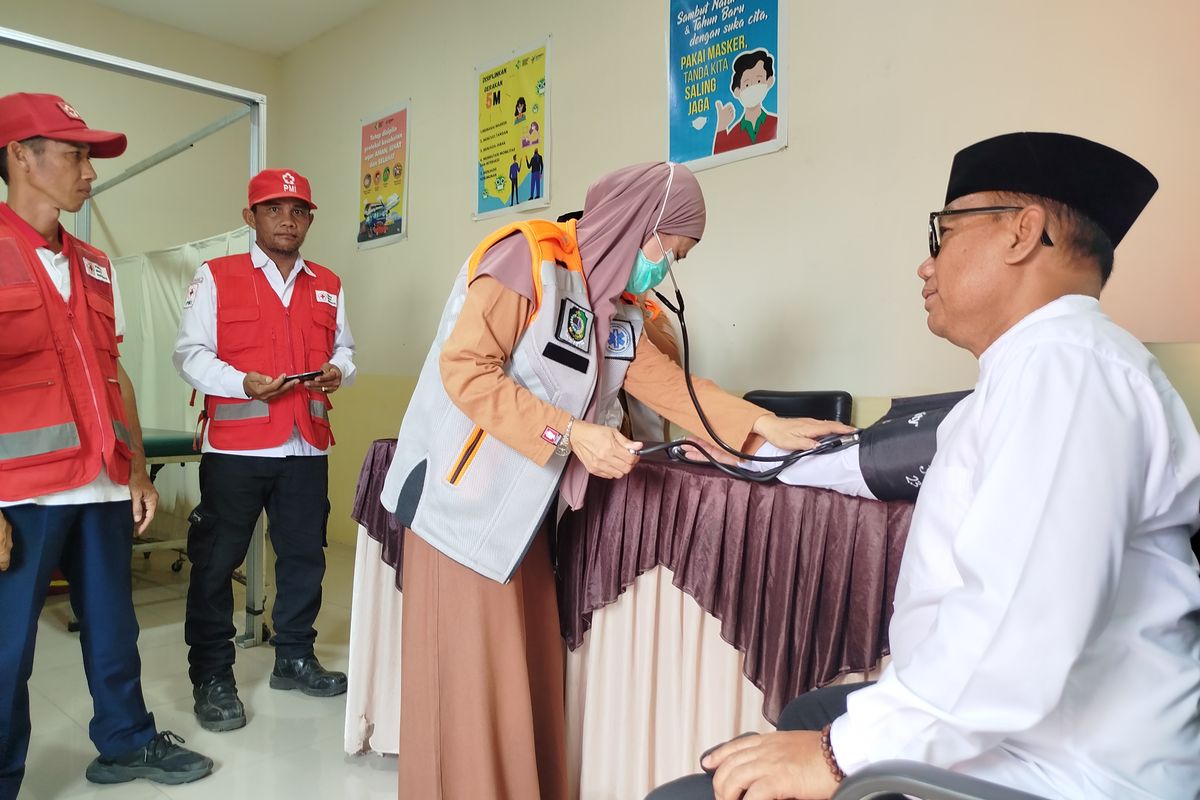 Siti Rohmah mengecek tensi Wakil Bupati Banyuwangi, Mujiono saat bertugas piket sebagai nakes di pos kesehatan Pelabuhan Ketapang, Selasa (25/3/2025) 