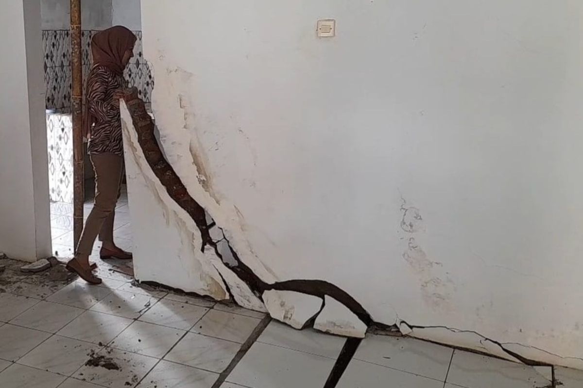 Kepala Desa Cikondang, Cineam, Kabupaten Tasikmalaya, Jawa Barat, Erios Rosita, sedang mengecek rumah warganya yang rusak berat akibat terdampak bencana pergerakan tanah pada Selasa (18/2/2025).