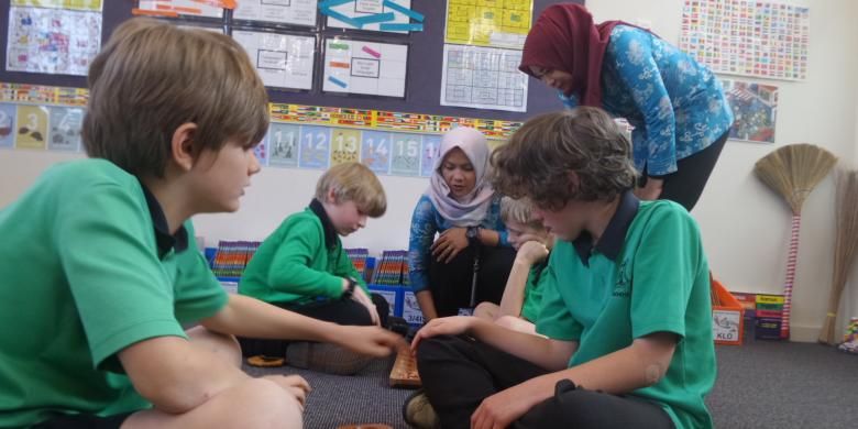 Anak-anak usia sekolah dasar di Turner School mengikuti pelajaran Bahasa Indonesia melalui permainan tradisional congklak. Dyah Candra Arbiningrum dan rekannya, guru dari Pangkalan Bun, Kalimantan Tengah, ikut mengajar sebagai guru pendamping saat mengikuti program Bridge.