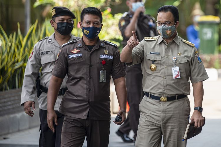 Gubernur DKI Jakarta Anies Baswedan (kanan) berjalan saat tiba di Gedung Merah Putih KPK, Jakarta, Selasa (21/9/2021). KPK memeriksa Anies Baswedan sebagai saksi untuk tersangka mantan Direktur utama Perumda Sarana Jaya Yoory Corneles Pinontoan (YRC) atas kasus dugaan korupsi pengadaan lahan di Munjul, Cipayung, Jakarta Timur. ANTARA FOTO/M Risyal Hidayat/wsj.