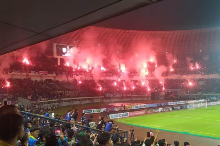 Sejumlah oknum bobotoh menyalakan flare atau suar di tribun utara Stadion Gelora Bandung Lautan Api (GBLA) Kota Bandung, Jawa Barat, Minggu (12/6/2022).  