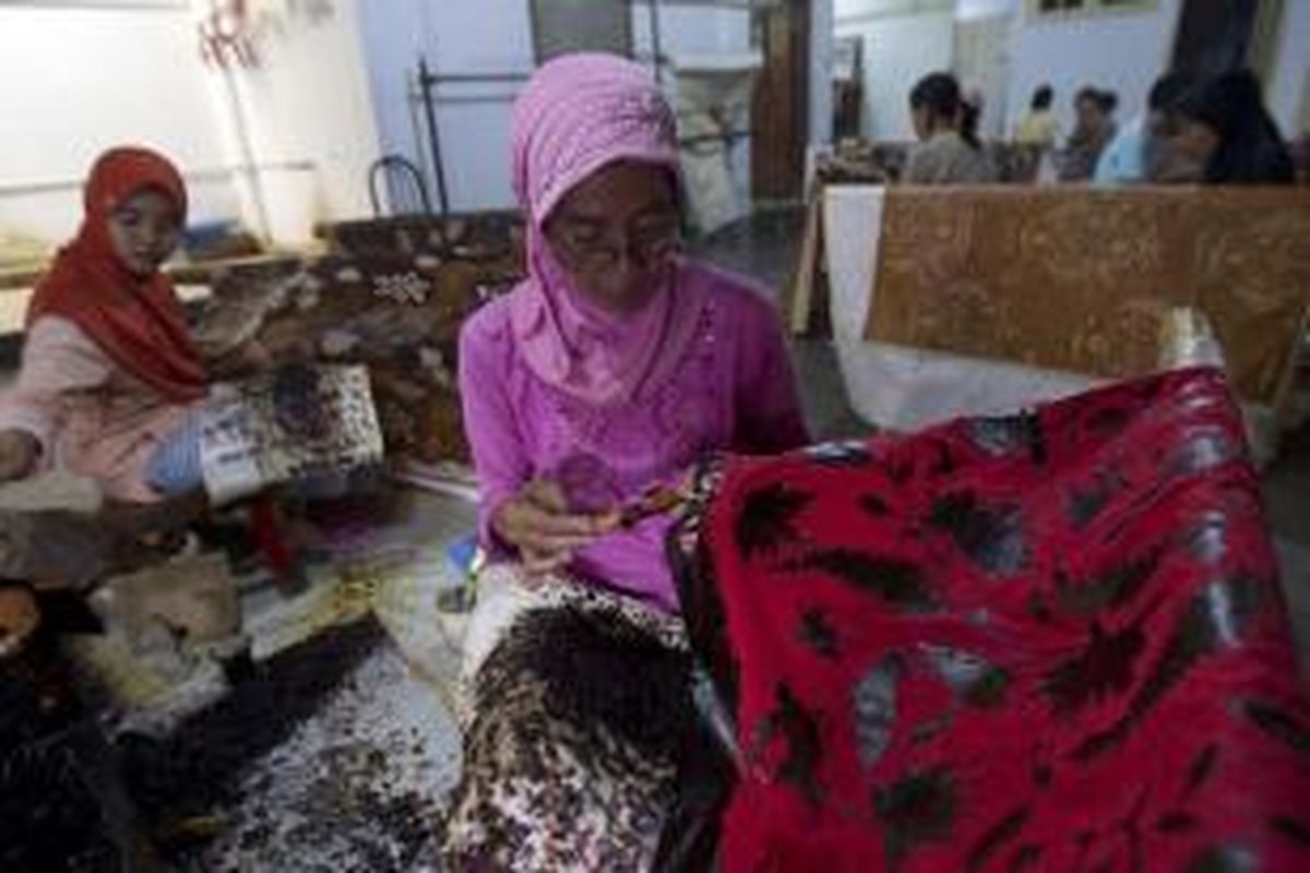 Para perajin membatik di bengkel kerja di kawasan Trusmi, Cirebon, Jawa Barat, Minggu (28/7/2013). Batik merupakan oleh-oleh yang biasa dibeli oleh para pemudik yang melewati jalur Cirebon.