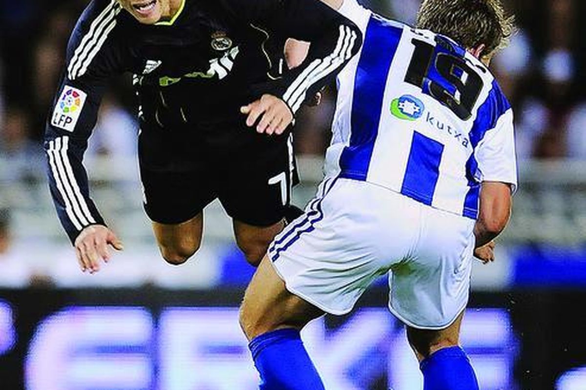 Pemain Real Madrid, Cristiano Ronaldo, terjungkal saat diganjal pemain Real Sociedad, Imanol Agirretxe, pada laga Liga Spanyol di Stadion Anoeta, San Sebastian, Spanyol, Sabtu (18/9). Real Madrid menang 2-1.