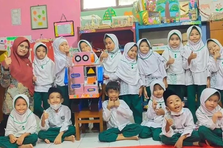 Nur Laela Nuszulfa (26), seorang guru Raudhatul Athfal (TK Islam) di Kudus memamerkan robot mesin ATM bersama anak-anak didiknya.