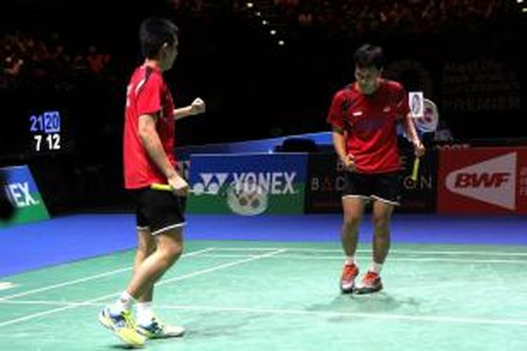 Ganda putra Indonesia Mohammad Ahsan (kanan)/Hendra Setiawan bereaksi setelah meraih poin saat menghadapi lawan senegara, Marcus Fernaldi Gideon/Markis Kido, pada semifinal All England yang berlangsung di National Indoor Arena, Birmingham, Sabtu (8/3/2014). Ahsan/Hendra menang 21-7, 21-12. 