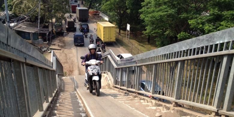 Seorang pengendara sepeda motor memacu kencang gas motornya agar bisa menanjak naik di salah satu jembatan penyeberangan di Jalan Lingkar Luar, Jakarta Barat, Selasa (5/5/2015).

