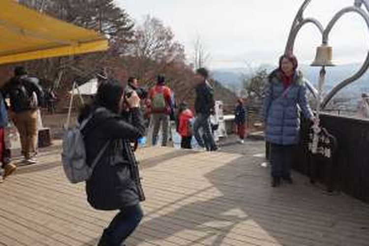 Wisatawan berfoto di bell of tenjo. Lonceng berbentuk hati kalau difoto seakan-akan persis berada di hadapan Gunung Fuji. Sangat diincar wisatawan untuk berfoto.