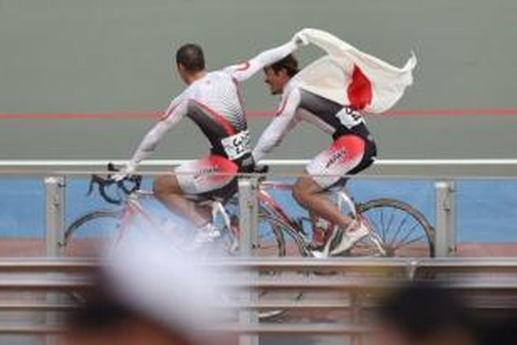 Seiichiro Nakagawa (kanan) dan Tomoyuki Kawabata (kiri)  melakukan selebrasi usai meraih medali emas dan perak di cabang balap sepeda nomor sprint di Asian Games 2014, Rabu (24/9/2014)