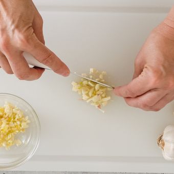Ilustrasi talenan plastik, memotong bawang putih di atas talenan plastik. 