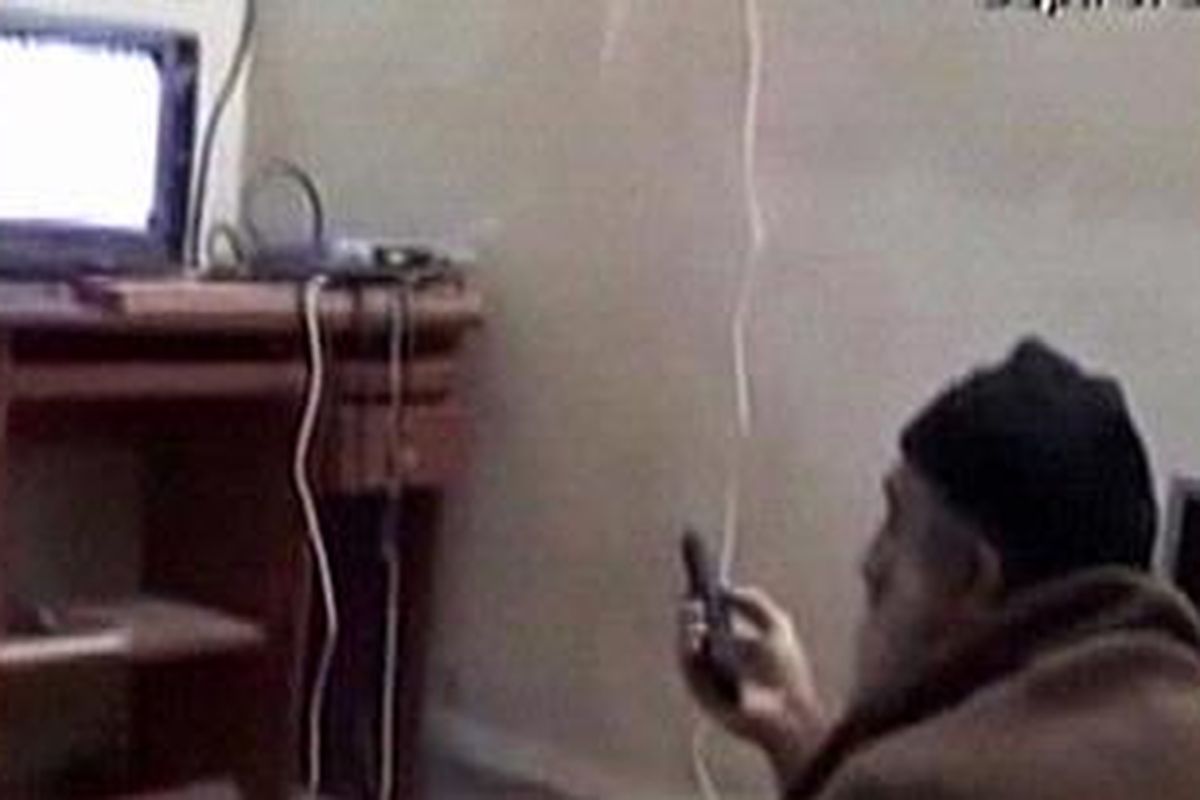 Image-obsessed: One of the five videos shows Bin Laden sitting on the dirty floor of the compound watching video footage of himself on television  