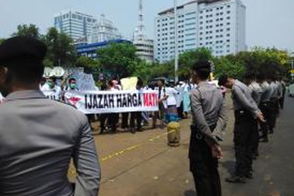 Puluhan dokter muda yang tergabung dalam Pergerakan Dokter Muda Indonesia (PDMI) pada Senin (7/9) di depan Istana Merdeka melakukan aksi unjuk rasa menolak kebijakan Dikti yang menahan ijazah akademik mereka