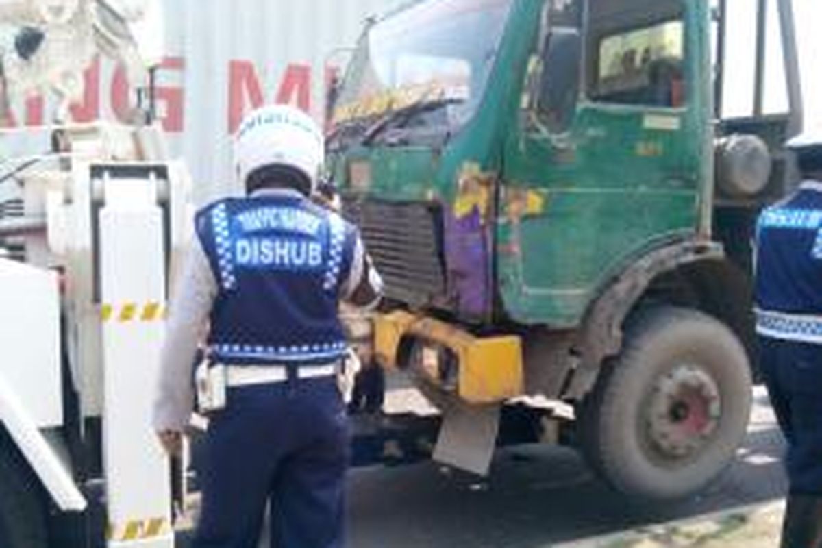 Petugas dari Dinas Perhubungan DKI Jakarta menderek truk yang parkir di sembarang tempat di jalan akses Marunda, Cilincing, Jakarta Utara, Senin (8/9/2014).