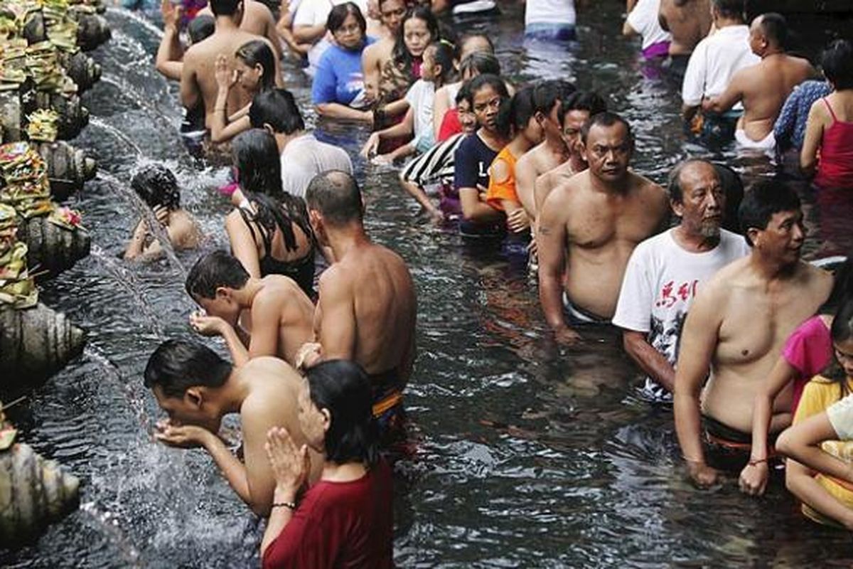 Umat Hindu dan wisatawan mengantre untuk menikmati kesegaran air pancuran di obyek wisata pemandian suci Tirta Empul yang menjadi satu kompleks dengan Istana Tampaksiring di Ubud, Bali, Minggu (7/8/2016). Potensi wisata alam dan adat menjadi andalan pariwisata Gianyar.