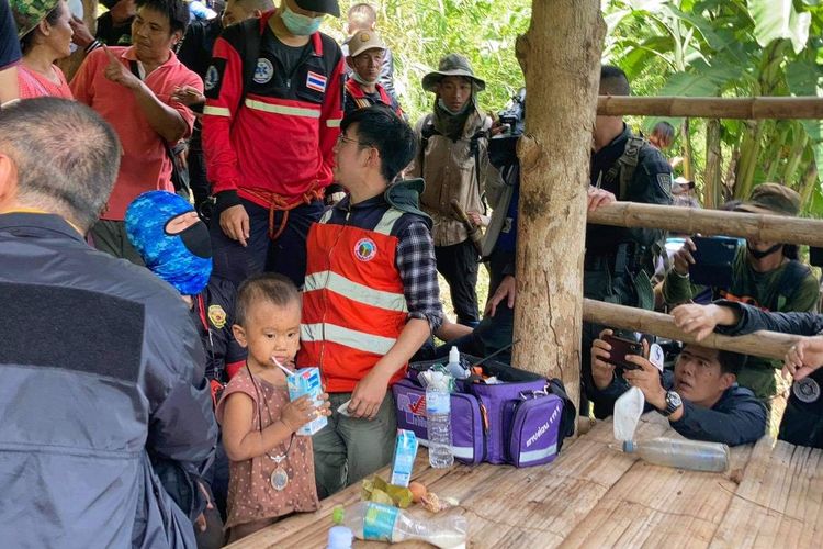 Gina (tengah) yang sedang minum susu dikelilingi oleh tim penyelamat dari Maena, Thailand. Dia ditemukan setelah menghilang selama 3 hari.