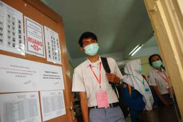 Sejumlah siswa SMK Bhakti Insani Kota Bogor menggunakan masker atau penutup hidung saat ujian nasional (UN) berlangsung karena tercemar oleh bau kotoran yang berasal dari kandang sapi yang berdekatan dengan sekolah itu, Selasa (5/4/2016).