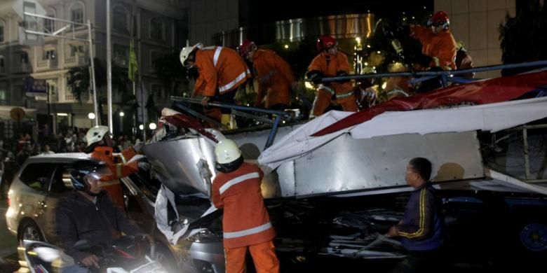 Papan reklame roboh akibat hujan deras yang disertai angin kencang di depan BCA Wisma Asia, Jalan S Parman, Jakarta, Selasa (22/4/2014). Papan reklame menimpa satu mobil, dua truk dan tiga sepeda motor. Kejadian tersebut mengakibatkan sejumlah orang luka-luka.