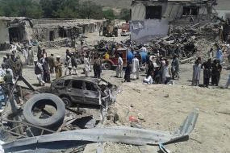 Warga distrik Urgun, provinsi Paktika, Afganistan berkerumun di bangkai truk yang meledak di sebuah pasar dan menewaskan 25 orang.