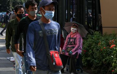 Pekerja menggunakan masker saat berjalan menuju perkantoran di Kawasan Tanah Abang, Jakarta Pusat, Senin (21/9/2020). PSBB kembali diterapkan mulai tanggal 14 September 2020, berbagai aktivitas kembali dibatasi yakni aktivitas perkantoran, usaha, transportasi, hingga fasilitas umum.